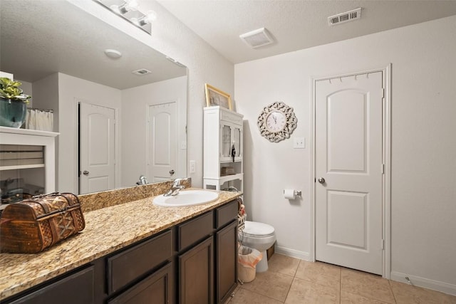 bathroom with tile patterned floors, baseboards, vanity, and toilet