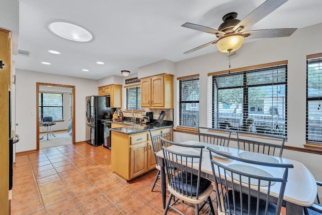 10804 Buckthorn Dr, Austin, TX 78759 - kitchen with black appliances, light brown cabinetry, plenty of natural light, dark countertops, and recessed lighting