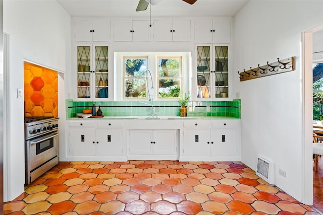806 Rosedale Ter, Austin, TX 78704 - bar with high end stainless steel range oven, decorative backsplash, light floors, and a ceiling fan