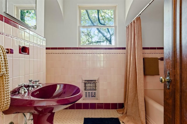 806 Rosedale Ter, Austin, TX 78704 - full bathroom featuring tile walls, healthy amount of natural light, a wainscoted wall, a sink, and shower / bath combination with curtain