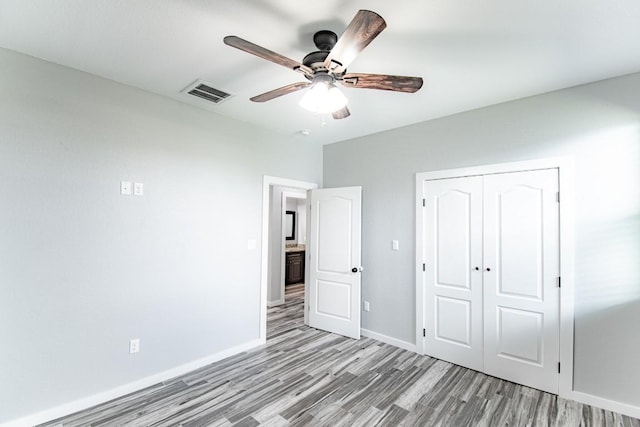 121 Grassy Ln, Elgin, TX 78621 - unfurnished bedroom featuring light wood finished floors, a closet, and ceiling fan