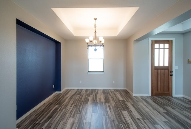 121 Grassy Ln, Elgin, TX 78621 - unfurnished room with wood finished floors, healthy amount of natural light, a chandelier, and a raised ceiling