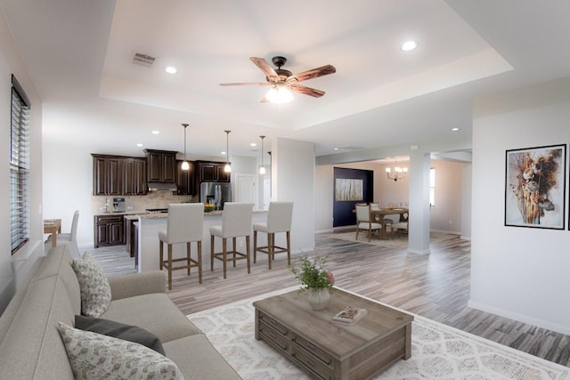121 Grassy Ln, Elgin, TX 78621 - living area featuring a raised ceiling, light wood finished floors, recessed lighting, and a ceiling fan
