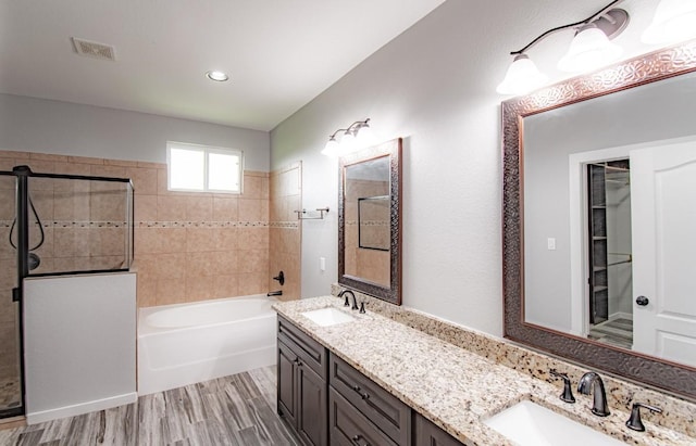 121 Grassy Ln, Elgin, TX 78621 - full bath with a tile shower, a bath, double vanity, wood finished floors, and recessed lighting