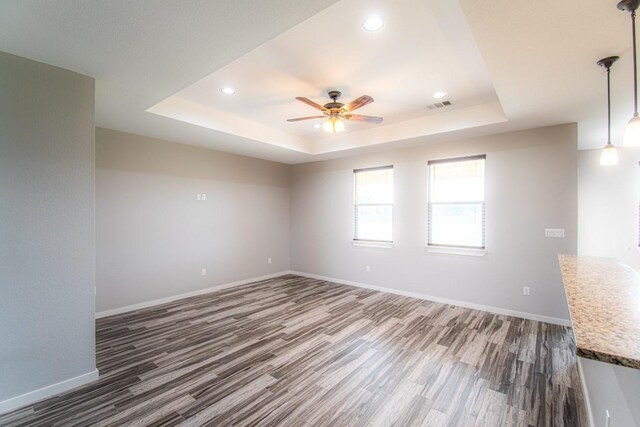 121 Grassy Ln, Elgin, TX 78621 - spare room with a tray ceiling, dark wood-style flooring, a ceiling fan, and recessed lighting