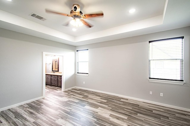 121 Grassy Ln, Elgin, TX 78621 - spare room featuring ceiling fan, a tray ceiling, light wood finished floors, and recessed lighting