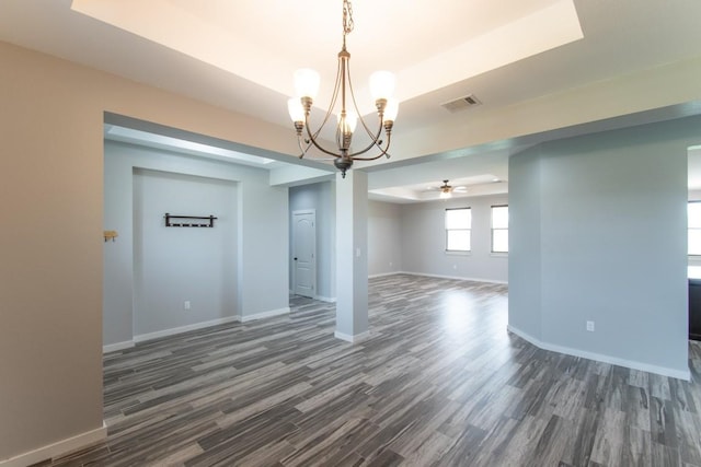 121 Grassy Ln, Elgin, TX 78621 - unfurnished room with a chandelier, dark wood finished floors, ceiling fan, and a raised ceiling