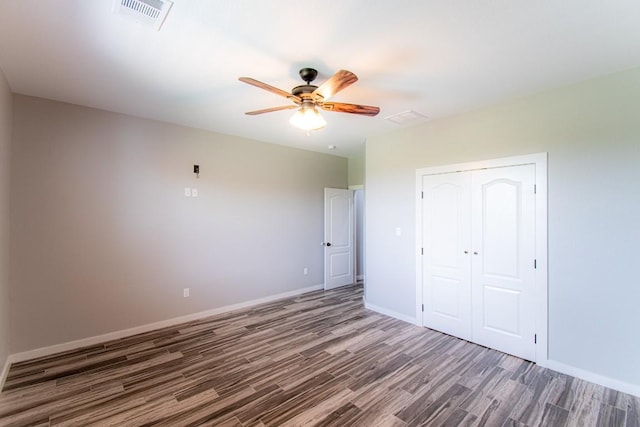 121 Grassy Ln, Elgin, TX 78621 - unfurnished bedroom with wood finished floors, a closet, and a ceiling fan