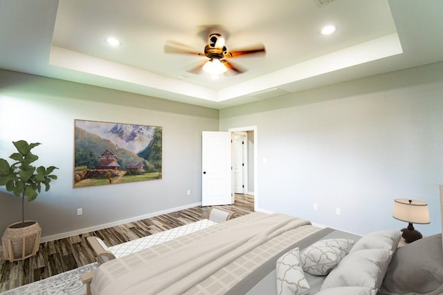 121 Grassy Ln, Elgin, TX 78621 - bedroom with a tray ceiling, wood finished floors, recessed lighting, and a ceiling fan