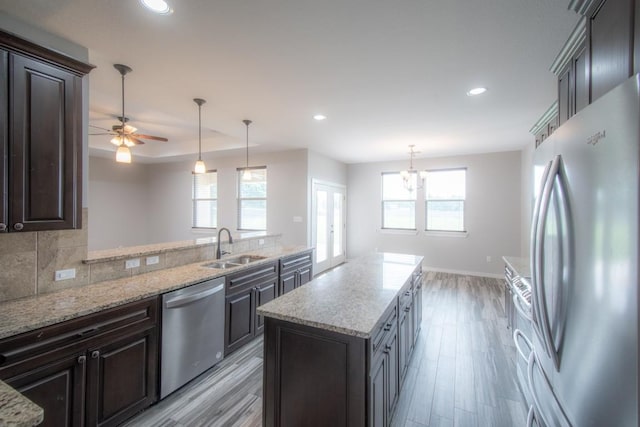 121 Grassy Ln, Elgin, TX 78621 - kitchen with appliances with stainless steel finishes, light wood-style floors, light stone countertops, recessed lighting, and ceiling fan