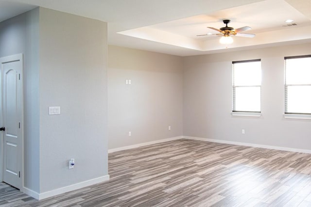121 Grassy Ln, Elgin, TX 78621 - spare room featuring wood finished floors, a tray ceiling, and a ceiling fan