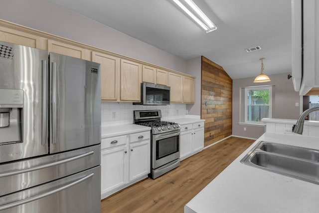 906 Mammoth Ct, Round Rock, TX 78681 - kitchen with stainless steel appliances, a sink, light wood finished floors, light countertops, and vaulted ceiling