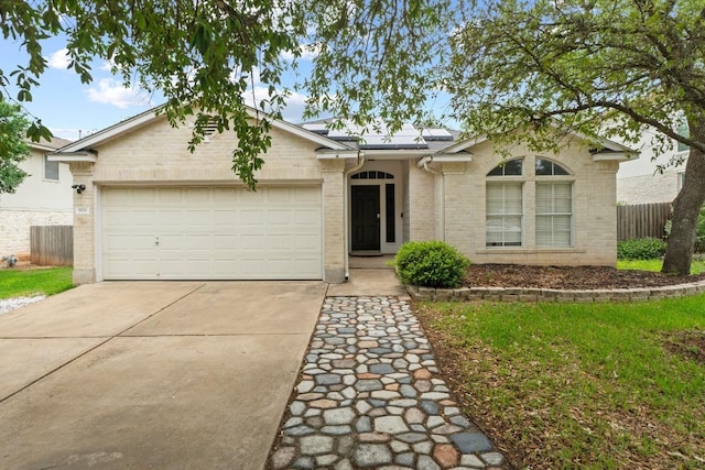 906 Mammoth Ct, Round Rock, TX 78681 - ranch-style home with driveway, roof mounted solar panels, a garage, and brick siding
