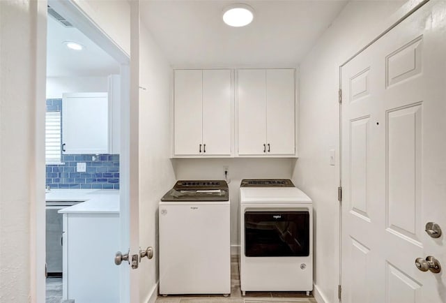 washroom with separate washer and dryer and cabinet space