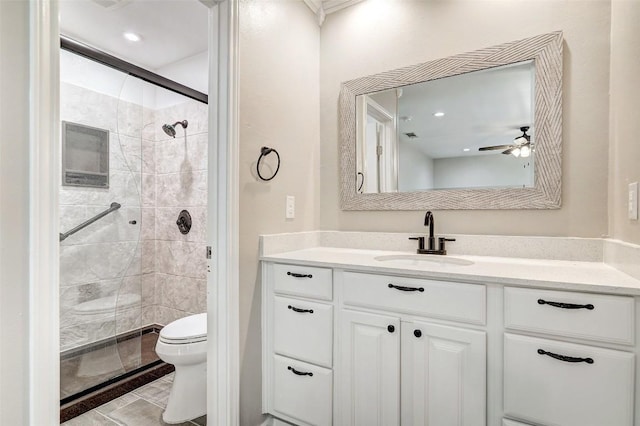 bathroom with toilet, a stall shower, vanity, and a ceiling fan