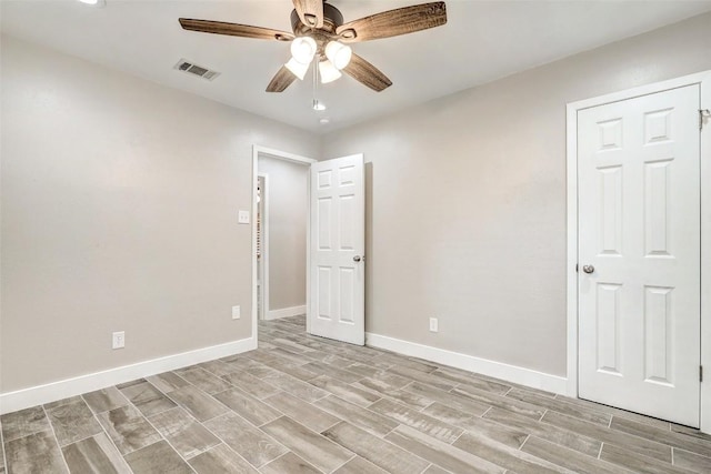 unfurnished bedroom featuring wood tiled floors, baseboards, and a ceiling fan