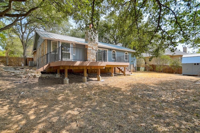 back of house with stairway, fence, a deck, and metal roof