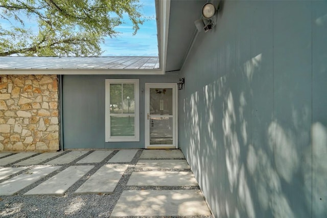 property entrance with a patio and metal roof