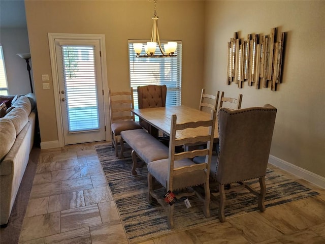 539 Tanda Ln, Hutto, TX 78634 - dining area featuring a chandelier, baseboards, and stone tile floors