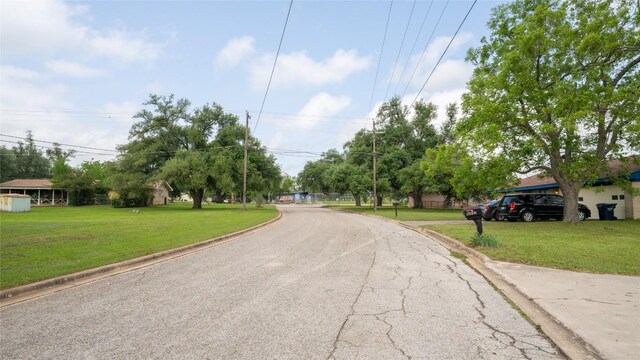 view of asphalt road featuring curbs