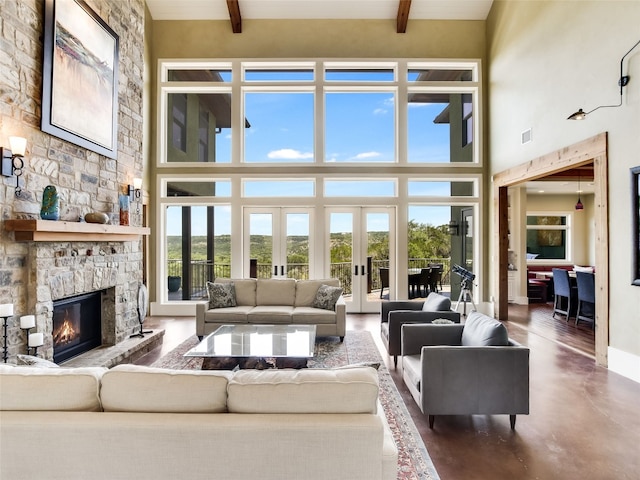 400 Hillview Rd, Wimberley, TX 78676 - living area with a high ceiling, beam ceiling, a stone fireplace, french doors, and finished concrete flooring