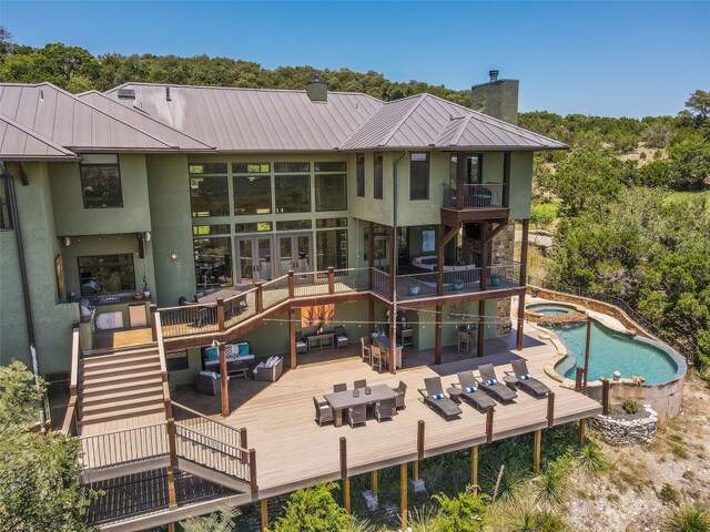 400 Hillview Rd, Wimberley, TX 78676 - rear view of house featuring an outdoor living space, a standing seam roof, a chimney, a deck, and stucco siding