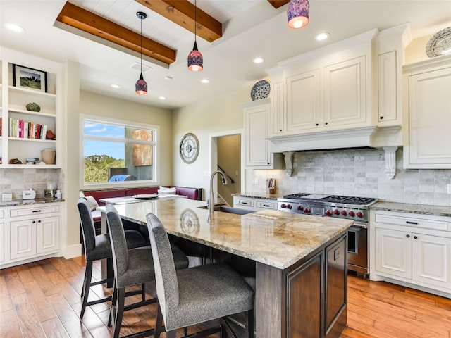 400 Hillview Rd, Wimberley, TX 78676 - kitchen featuring high end stainless steel range, a sink, light stone countertops, beamed ceiling, and white cabinets
