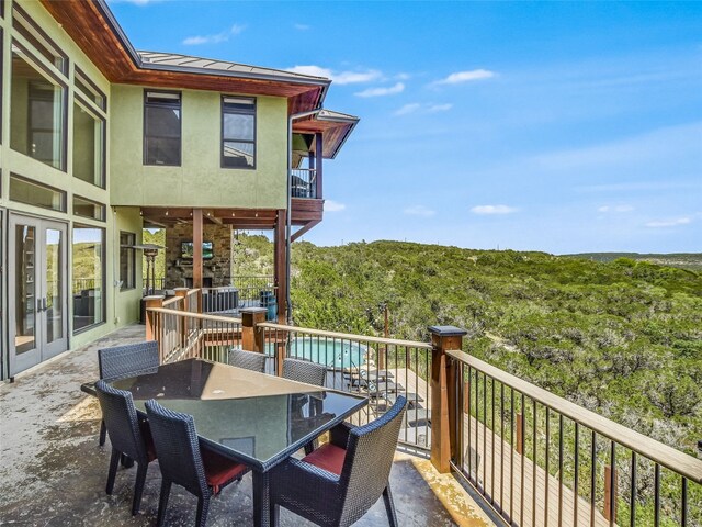 400 Hillview Rd, Wimberley, TX 78676 - wooden deck with french doors, outdoor dining area, and a view of trees