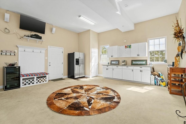 1016 High Hill Creek Rd, La Grange, TX 78945 - interior space featuring light carpet, beverage cooler, baseboards, and a towering ceiling