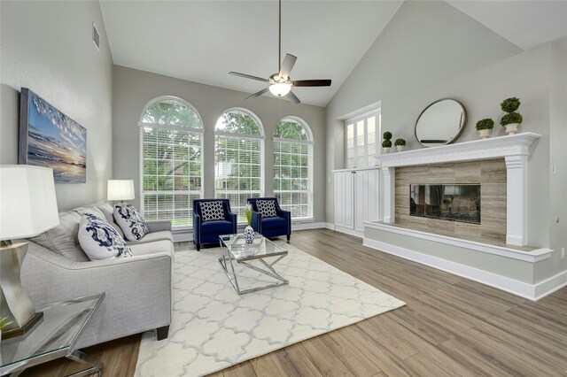 4933 China Garden Dr, Austin, TX 78730 - living room with ceiling fan, wood finished floors, lofted ceiling, a tile fireplace, and baseboards