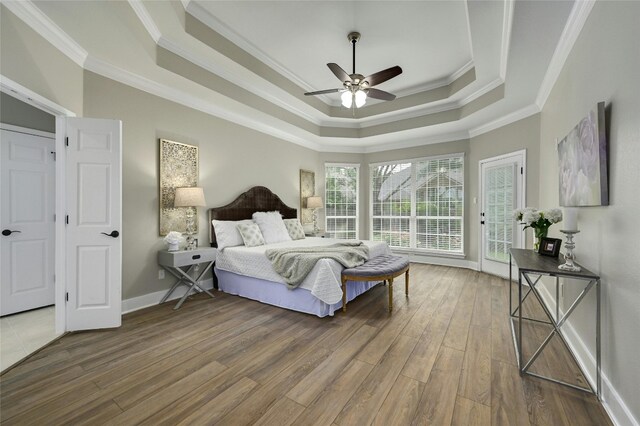 4933 China Garden Dr, Austin, TX 78730 - bedroom featuring crown molding, a raised ceiling, access to exterior, wood finished floors, and baseboards