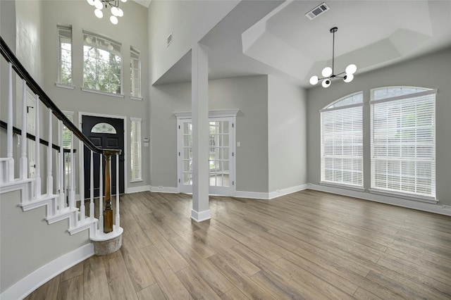 4933 China Garden Dr, Austin, TX 78730 - foyer entrance featuring a chandelier, a raised ceiling, baseboards, wood finished floors, and stairway