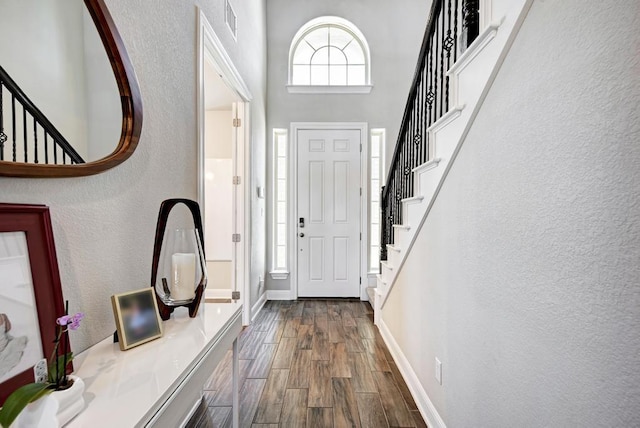 1816 Ficuzza Way, Leander, TX 78641 - foyer entrance with dark wood-style flooring, stairs, plenty of natural light, a textured wall, and a towering ceiling