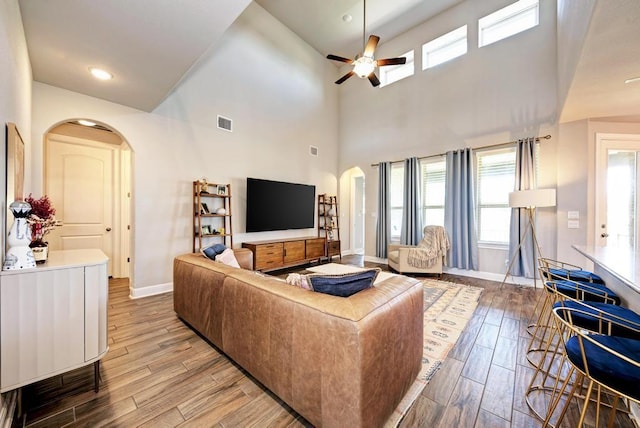 1816 Ficuzza Way, Leander, TX 78641 - living area featuring arched walkways, wood finished floors, ceiling fan, a high ceiling, and recessed lighting