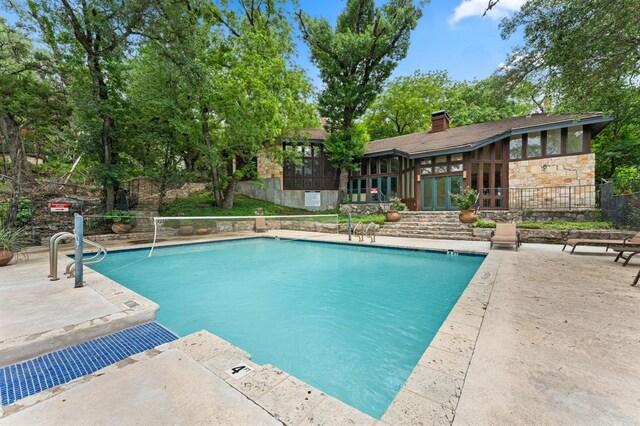 community pool featuring fence and a patio