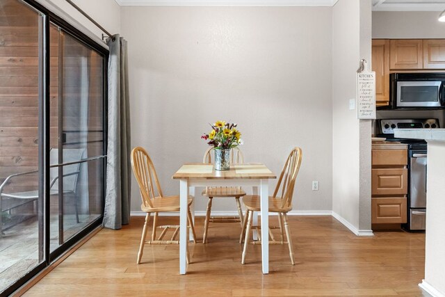 dining space featuring light wood finished floors and baseboards