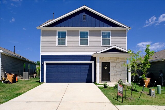 traditional-style house featuring board and batten siding, an attached garage, stone siding, and a front lawn
