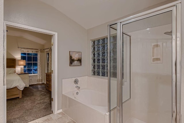 bathroom with connected bathroom, lofted ceiling, a stall shower, and a garden tub