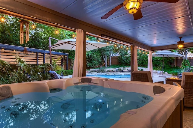 view of pool featuring a hot tub, a ceiling fan, and a fenced backyard