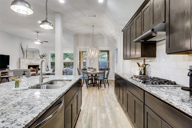 kitchen featuring under cabinet range hood, appliances with stainless steel finishes, dark brown cabinets, a sink, and recessed lighting
