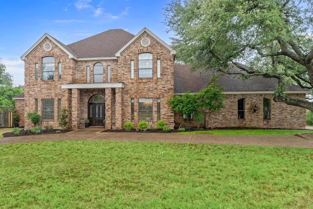 8900 Bell Mountain Dr, Austin, TX 78730 - view of front of house featuring roof with shingles, a front yard, brick siding, and french doors