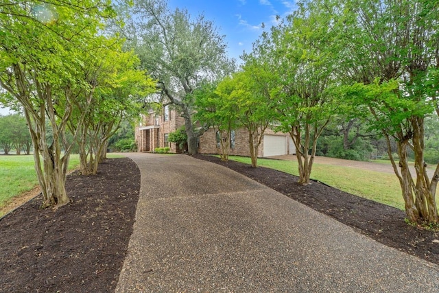 view of front of house with asphalt driveway, a front lawn, and brick siding