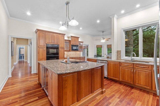 8900 Bell Mountain Dr, Austin, TX 78730 - kitchen featuring black appliances, tasteful backsplash, light stone counters, an island with sink, and healthy amount of natural light