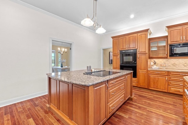8900 Bell Mountain Dr, Austin, TX 78730 - kitchen featuring black appliances, wood finished floors, a kitchen island, crown molding, and tasteful backsplash