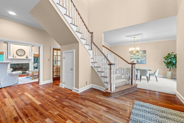 8900 Bell Mountain Dr, Austin, TX 78730 - foyer entrance with stairway, wood finished floors, a chandelier, crown molding, and a high end fireplace