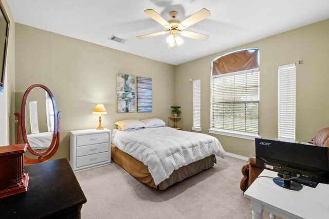 bedroom with light carpet, baseboards, and a ceiling fan