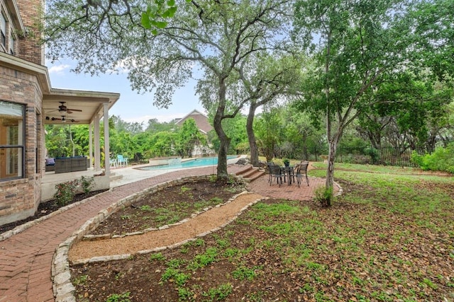 view of yard with ceiling fan, a patio, an outdoor pool, and fence