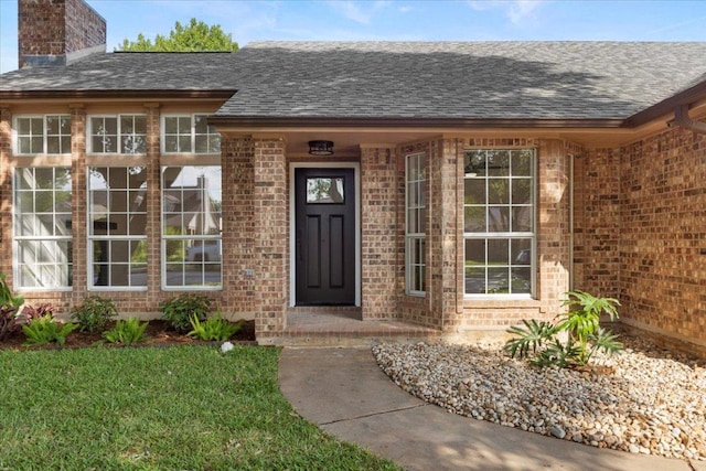 2310 Raintree Path, Round Rock, TX 78664 - entrance to property with a shingled roof, brick siding, a chimney, and a yard