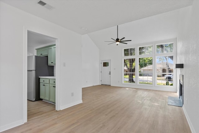 2310 Raintree Path, Round Rock, TX 78664 - unfurnished living room featuring ceiling fan, light wood-style floors, baseboards, a fireplace with flush hearth, and vaulted ceiling