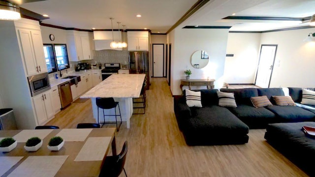 living room featuring ornamental molding, light wood-style flooring, and recessed lighting